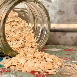 Freshly fed sourdough starter in a jar beside flour and water